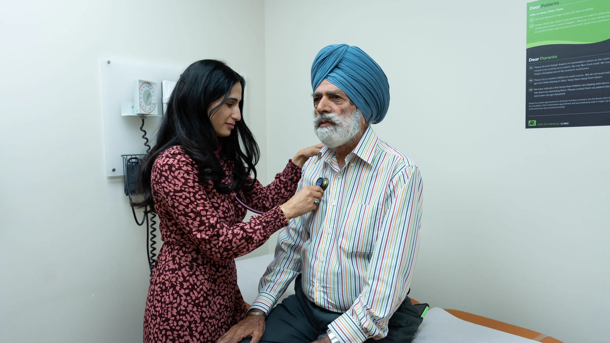A clinician listening to an older man's heart with a stethoscope during an exam